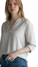 Cargar imagen en el visor de la galería, Anillo Foglia de ErikaRivas con diseño de hoja plateada texturizada lucido por una modelo con blusa clara
