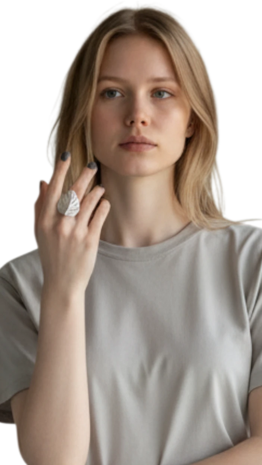 Modelo luciendo el Anillo Foglia de ErikaRivas, un diseño plateado con forma de hoja en su mano derecha.