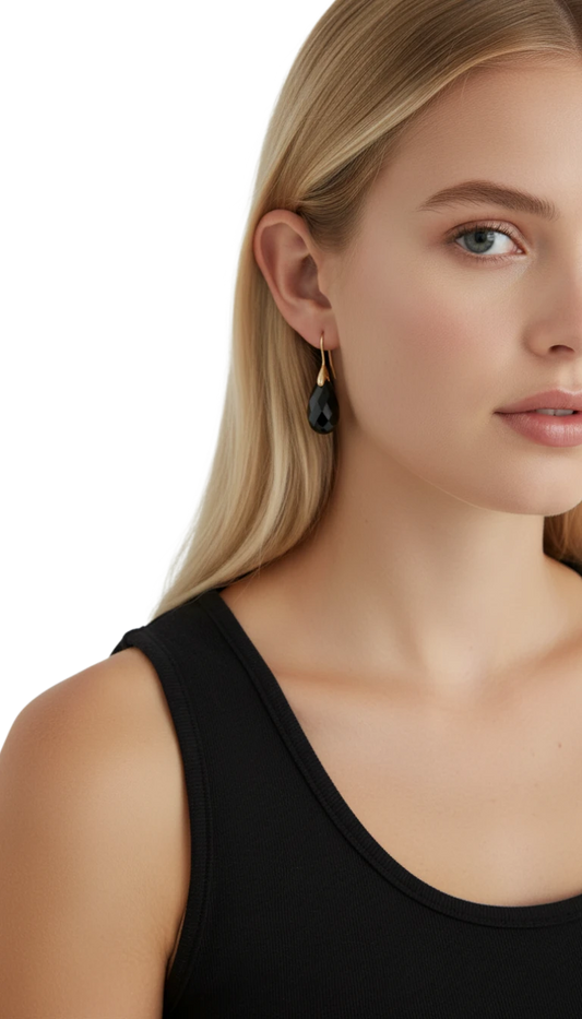Aretes Borough de ErikaRivas con piedra negra en forma de gota y gancho de oro puestos en una modelo