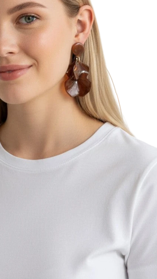 Modelo rubia luciendo aretes Hampstead de ErikaRivas en resina color café con diseño de pétalos orgánicos