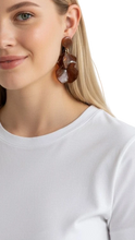 Cargar imagen en el visor de la galería, Modelo rubia luciendo aretes Hampstead de ErikaRivas en resina color café con diseño de pétalos orgánicos
