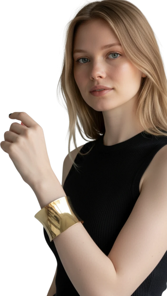 Modelo luciendo un brazalete estructurado ErikaRivas de metal dorado con acabado pulido y diseño ancho